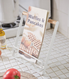 White Tablet and Cookbook Stand on kitchen counter holding cookbook by Yamazaki home. view 5