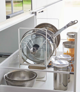 Side view of white Yamazaki Home Adjustable Pots and Pans Organizer in a drawer storing pots and lids view 7