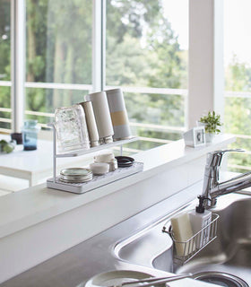 White Countertop Bottle Drying Rack holding bottles and jars on sink countertop by Yamazaki Home. view 3