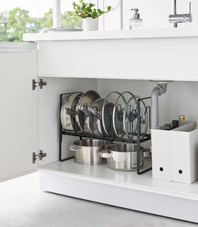 Black Yamazaki Home Adjustable Pots and Pans Organizer underneath a sink storing pots and lids view 12