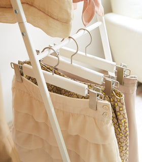 Close up view of white 2-level Coat Rack displaying skirts by Yamazaki Home. view 5