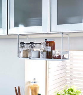 White Undershelf Organizer holding cooking ingredients by Yamazaki Home. view 2