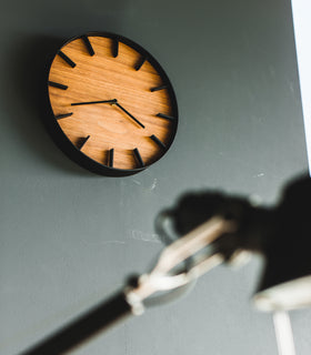 Angled up view of black Wall Clock on wall by Yamazaki Home. view 9