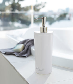 Front view of white Shampoo Dispenser on bathtub edge by Yamazaki Home. view 2