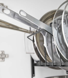 Close up of black Yamazaki Home Adjustable Pots and Pans Organizer in a drawer storing pots view 14