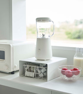 White Yamazaki Home Stackable Countertop Shelf with a blender above and a basket underneath view 4