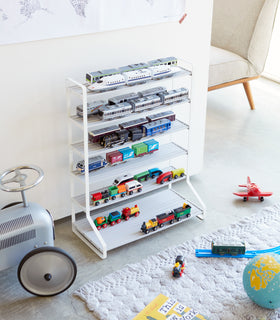 White Kids' Parking Garage displaying toy cars and trains in playroom by Yamazaki Home. view 3