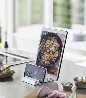 White Phone and Tablet Stand holding tablet and phone on kitchen countertop by Yamazaki Home. view 2