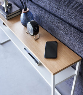 Close up of white Yamazaki Home Long Console Table - Shelf  with a phone and clock on it view 22