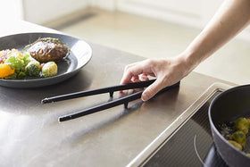 Black Floating Tweezer Tongs on kitchen counter by Yamazaki Home. view 15