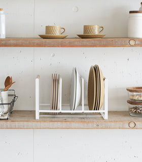 Front view of Wood-Accented Dish Storage Rack displaying plates on kitchen shelf by Yamazaki Home. view 4