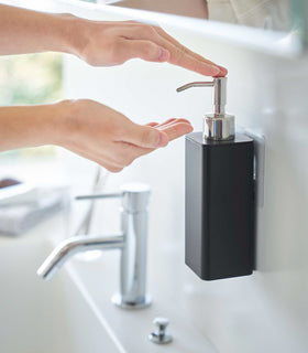 Dispensing soap from black Yamazaki Home square soap onto hands view 11