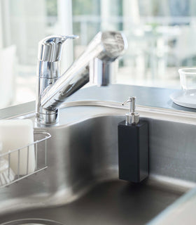 Black Yamazaki Home square soap dispenser hooked on the side of kitchen sink view 12