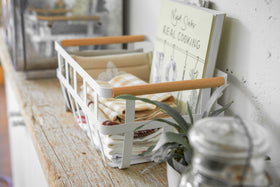 Side view of white Storage Basket holding book and cloth napkins on shelf by Yamazaki Home. view 12